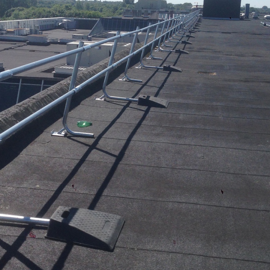 Freestanding roof edge (perimeter) guardrailing shown near parapet edge.